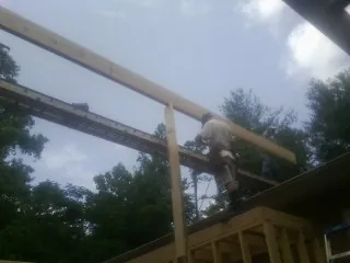 Carpenter setting a ridge beam over a new addition frame — Ice Dam Removal by Roofing Brothers in Floral