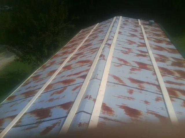 Rusted metal roof panels with new wood purlins before replacement — Storm Damage Roof Repair in Floral by Roofing Brothers