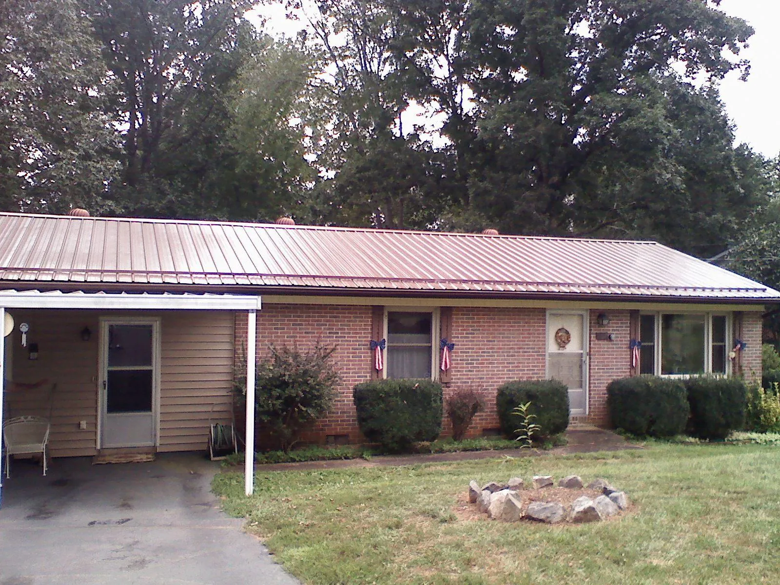 Bronze metal roof and carport on a brick ranch home — Roof Repair work by our crew in Floral